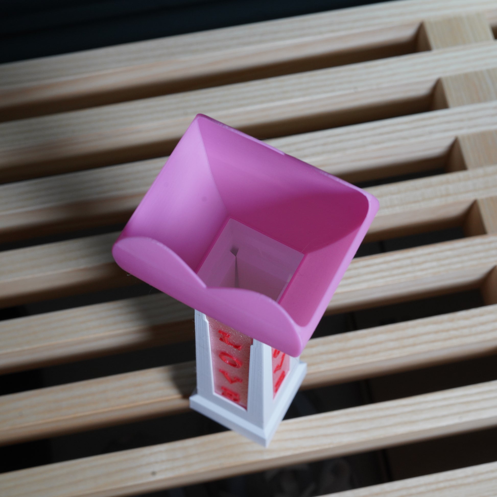 Pink and white plastic tool on a wooden surface