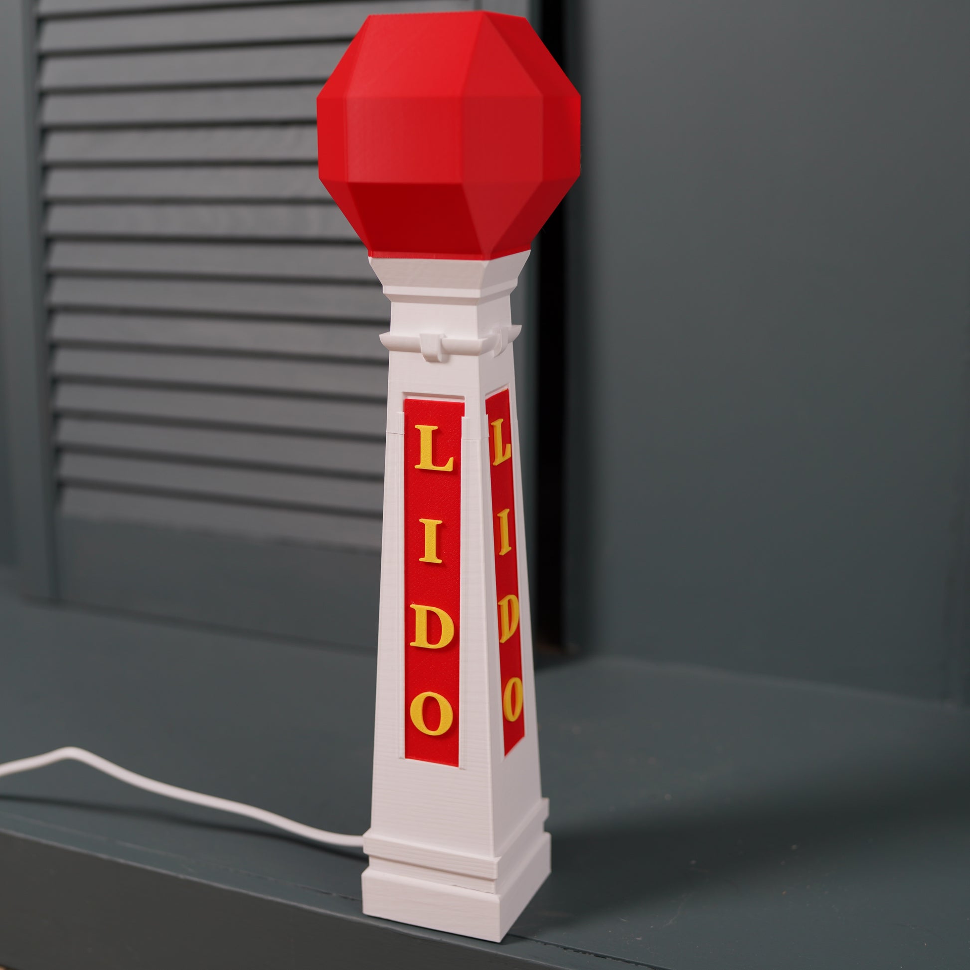 Margate Lido table lamp with E14 bulb with red and white design on a dark background