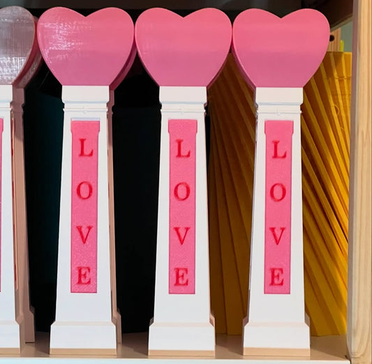 A set of decorative desk items with 'LOVE' printed on them, featuring pink heart-shaped tops.