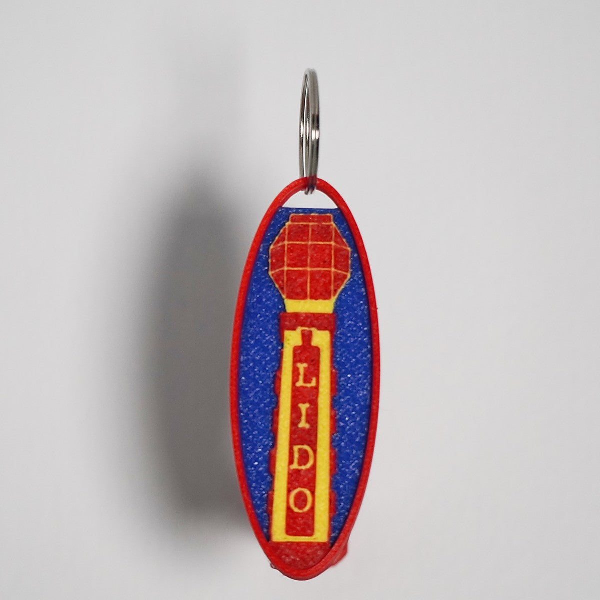 A keyring with a blue, red, and yellow design featuring the word 'LIDO' on a shield-like emblem.