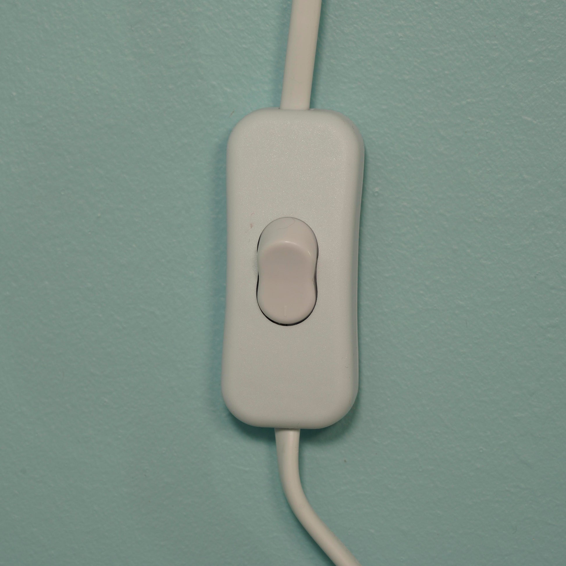 White wall switch on a light blue wall